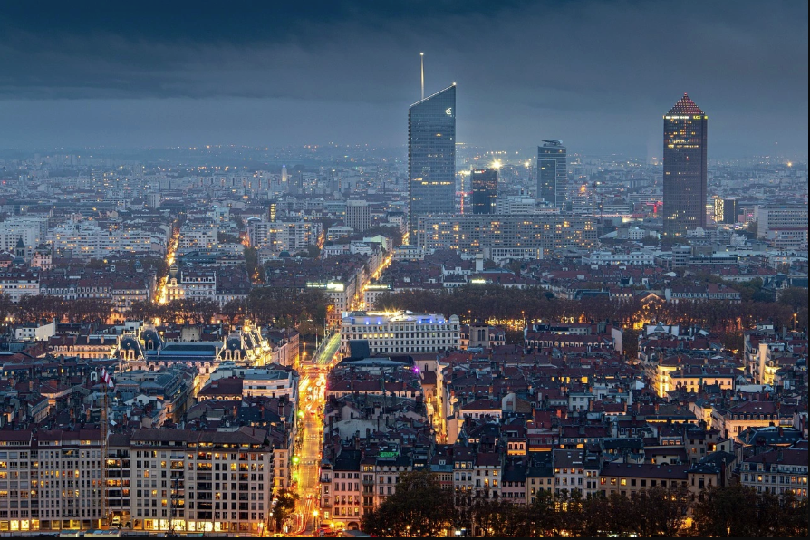 Aerial view of Lyon at night during the Festival of Lights, with the city’s skyline glowing.