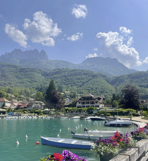 Lake Annecy with boats, flowers and Alpine mountains – ideal filming location in Haute-Savoie