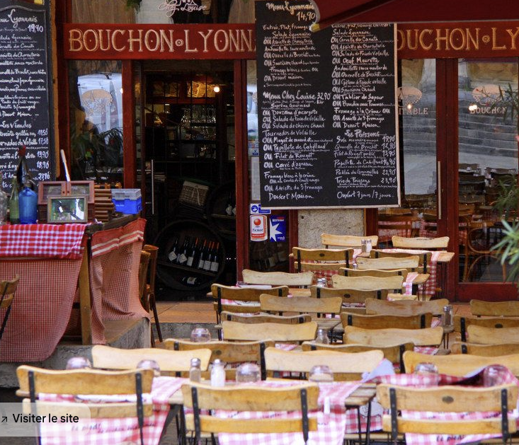 Outdoor terrace of a typical Lyonnais bouchon with checkered tablecloths and handwritten menus