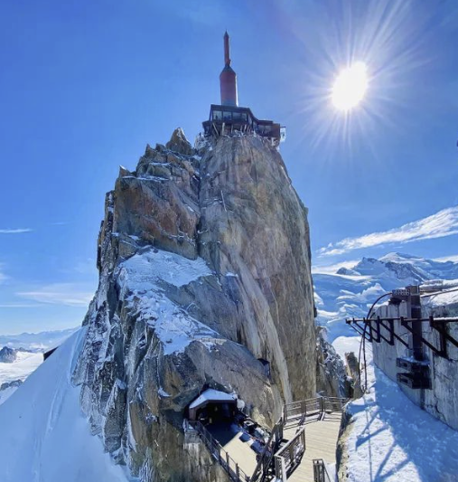 Observation deck atop the Aiguille du Midi with snowy peaks under bright sun